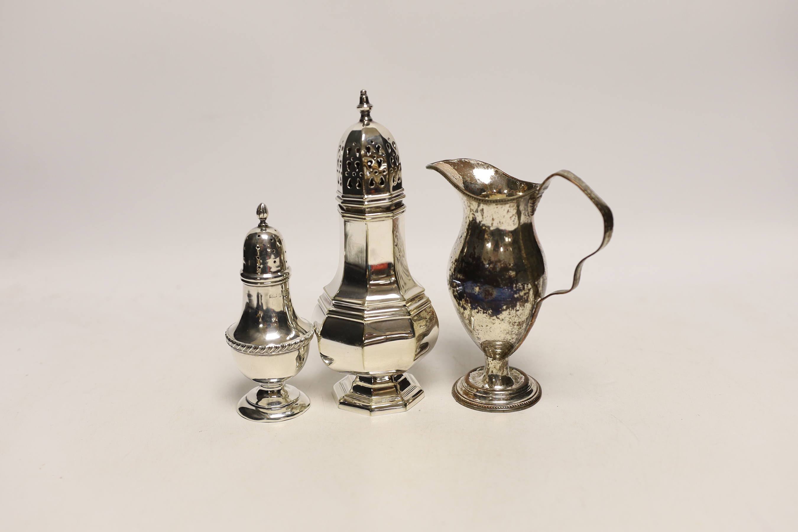 A George V silver pepperette, a silver plated sugar caster and a plated on copper cream jug.